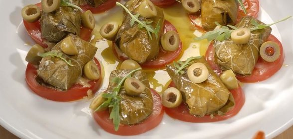 Козий сыр в виноградных листьях с томатами и оливками
