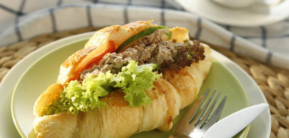 Круассан с тунцом, листьями салата и помидором